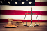 Law scales, judge gavel on table front of USA flag retro photo